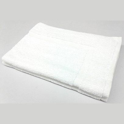 White, plush non-slip bath mat for hotels and motels, featuring a classic border design.