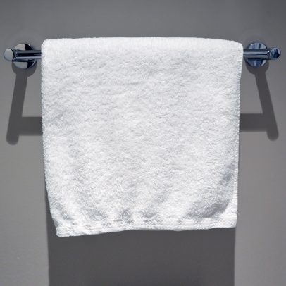 Plush white hand towel for hotel and motel guests, showcasing its soft and absorbent texture.