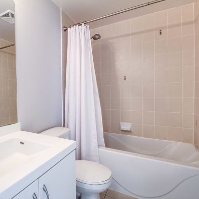 White waterproof hotel shower curtain hanging in bathroom