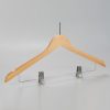Angled view of women’s natural wood hotel hanger with chrome clips
