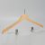 Angled view of women’s natural wood hotel hanger with chrome clips