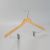 Angled view of natural wood women’s hanger with open hook and clips