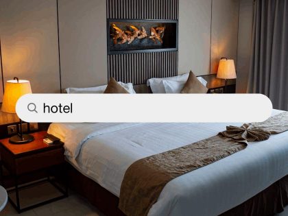 A clean, modern luxury hotel bedroom with a neatly made bed, elegant decor, and a large search bar overlay with the word “hotel”